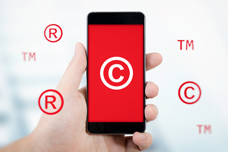 cell phone concept showing copyright, trademark, and registered trademark symbols